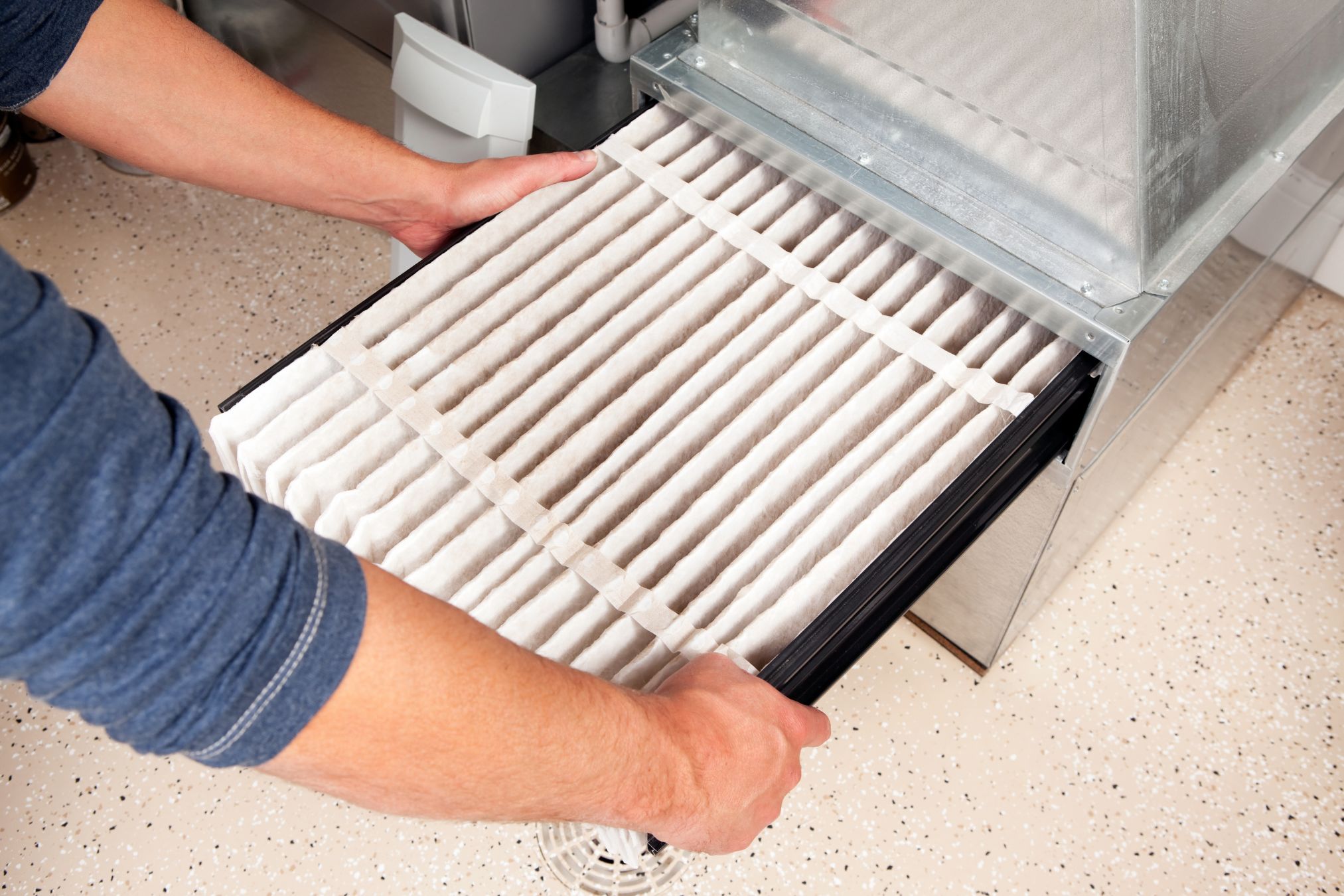 A reliable hvac Atlanta technician removing a filter from an air conditioner.