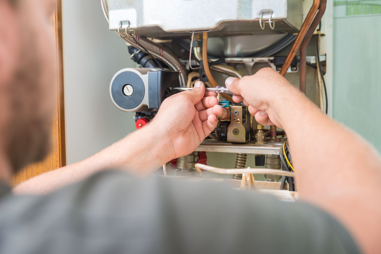 A man is servicing a hot water heater.