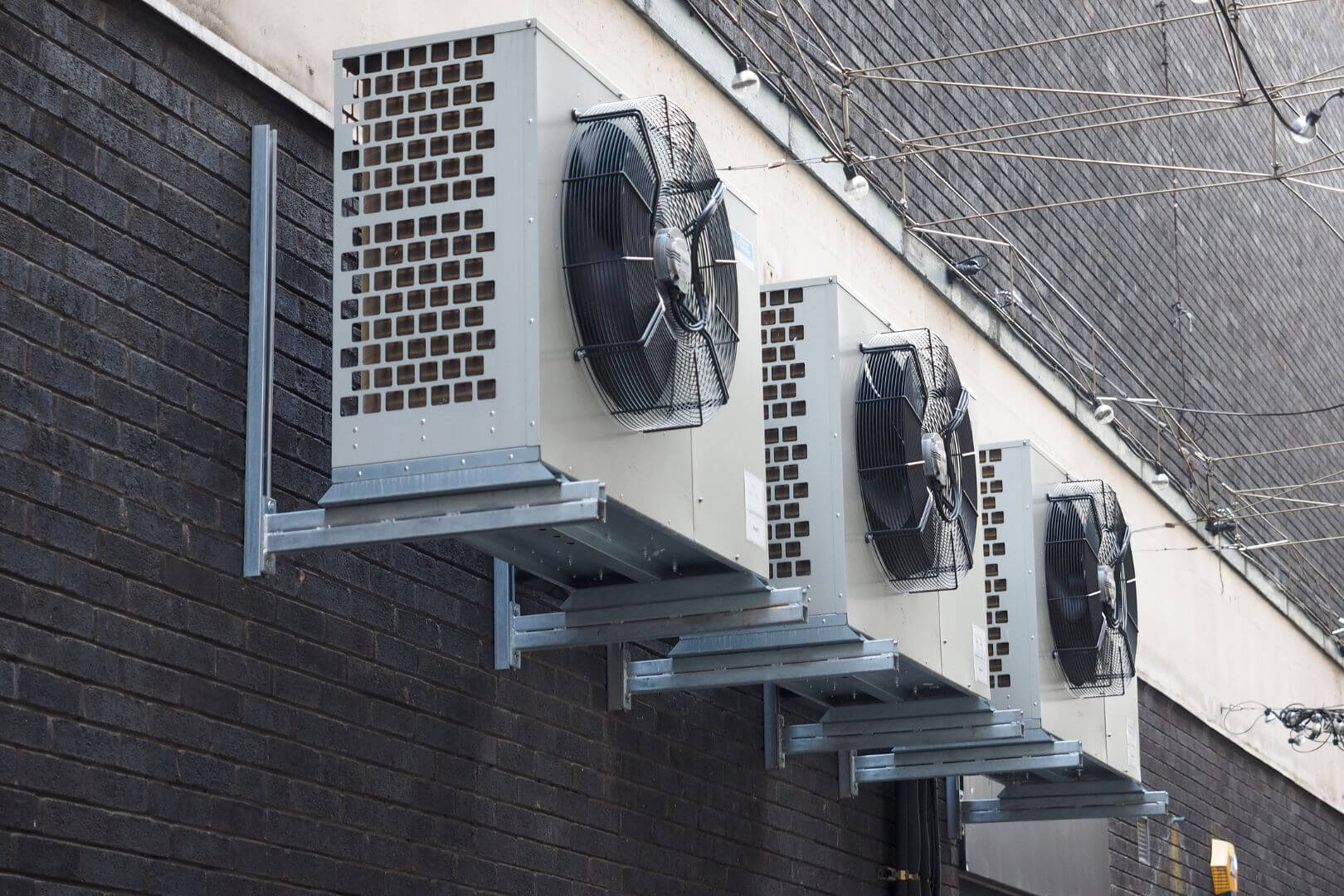 A group of commercial HVAC units on the side of a building.