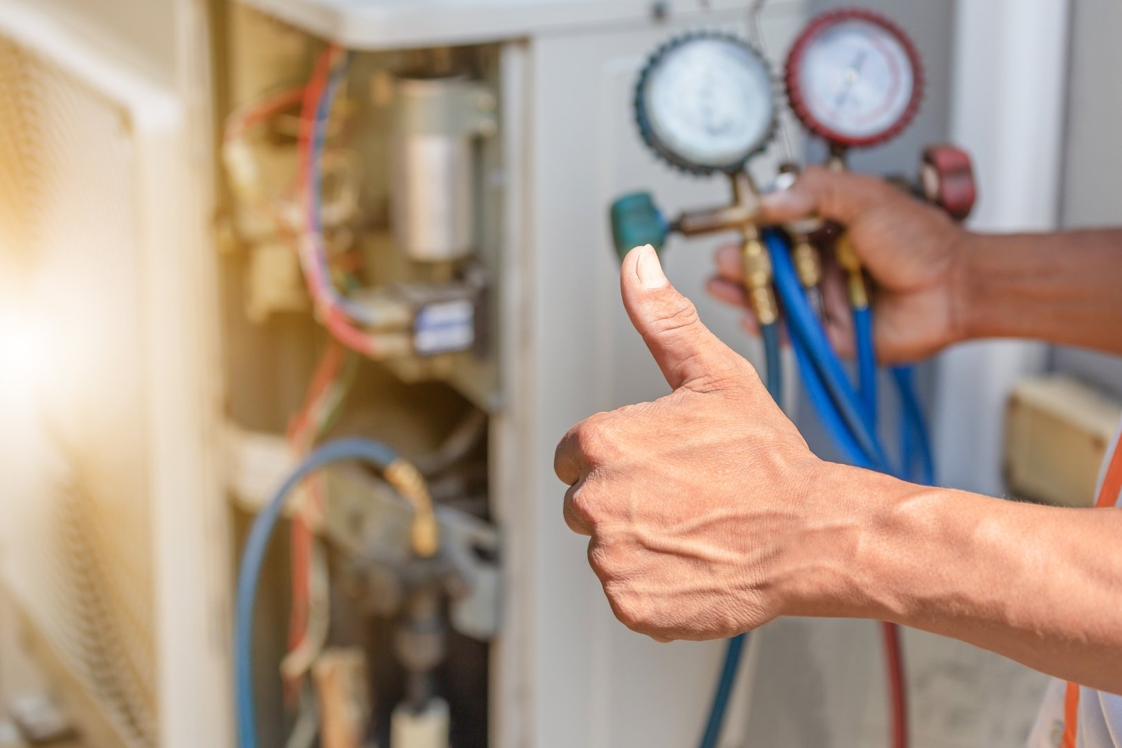 A man giving a thumbs up to an air conditioning unit.