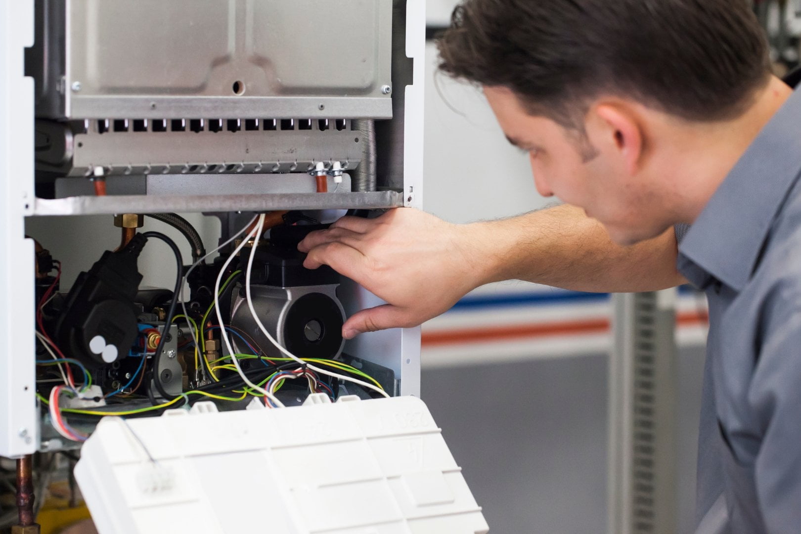 A man is working on a gas furnace for a reliable Heating and Air Company.