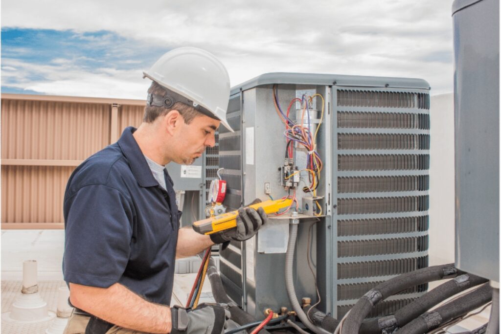 A man working on an air conditioning unit, ensuring that he has chosen the right HVAC contractor for the job.