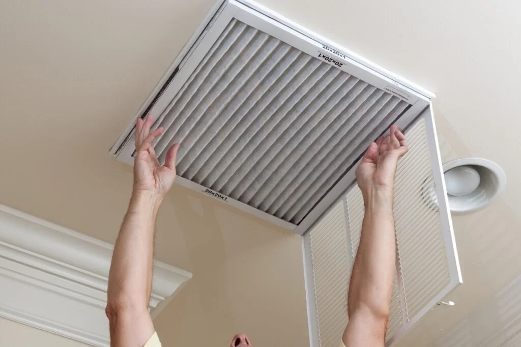 A person holding up an air filter, promoting HVAC air quality.