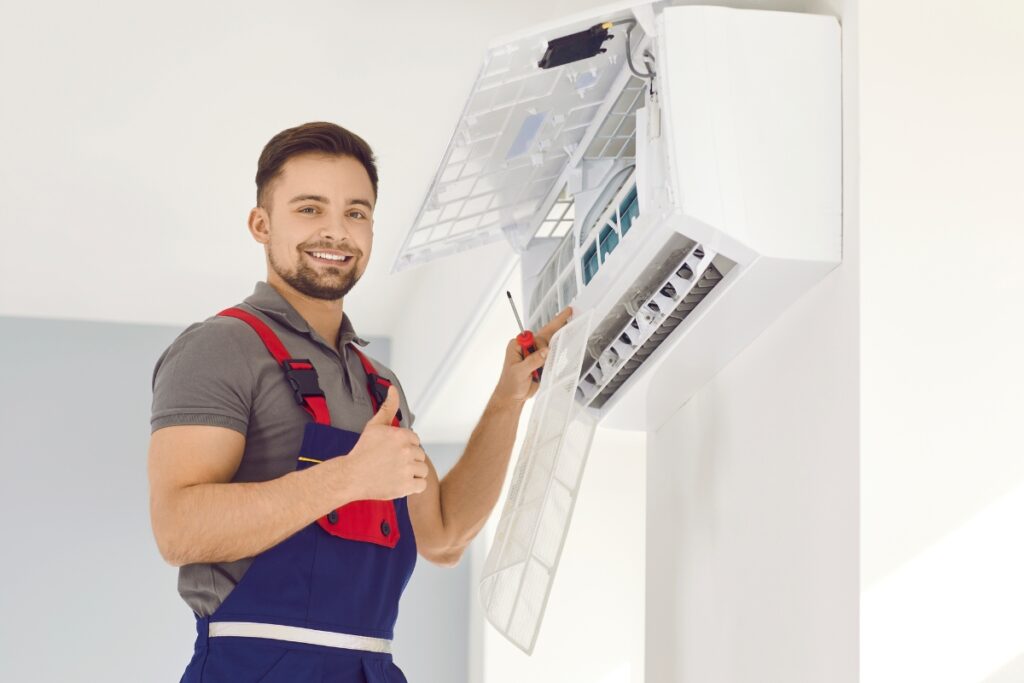 Technician smiling while servicing an air conditioning unit in the Georgia climate.