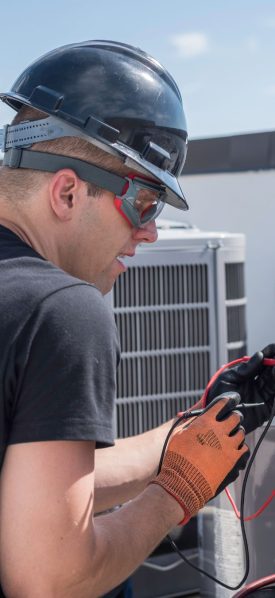 A reliable HVAC technician in Atlanta working on an air conditioning unit.