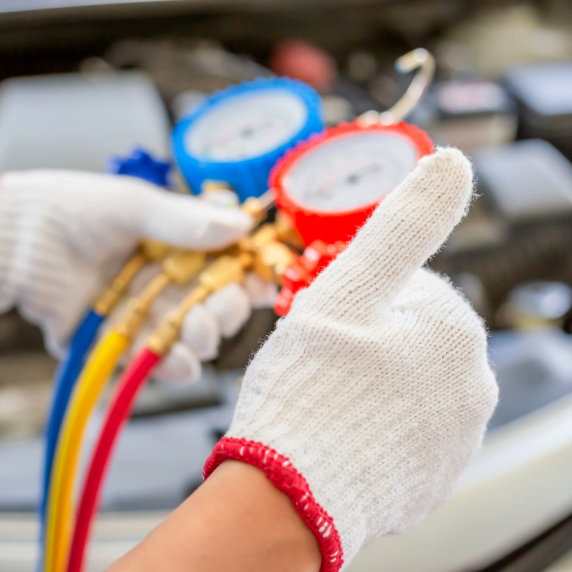 A man performing HVAC maintenance on a car.