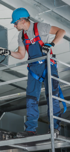 A man on a ladder in an Atlanta industrial building.