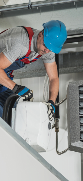 A Decatur HVAC Company technician servicing an air conditioning unit in a building.