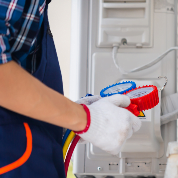 A technician from a Decatur HVAC company repairing an air conditioning unit.