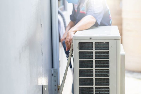 Technician performing maintenance on an outdoor air conditioning unit in the Georgia climate.