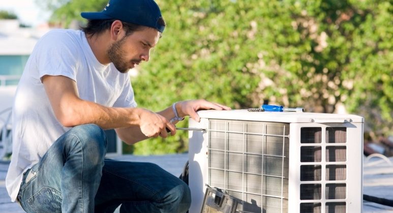 A man providing AC repair services on a roof.