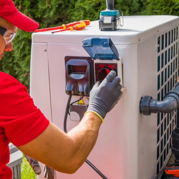 An HVAC technician from Hiram company is working on an air conditioner.