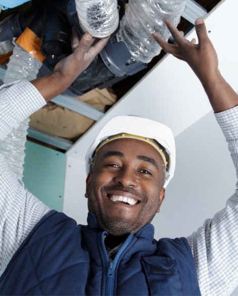 A man is holding up a pipe in a room offering services.