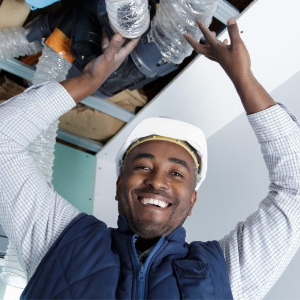 A man is holding up a pipe in a room offering services.