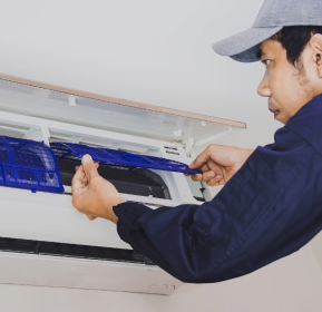 A man repairing an air conditioner.