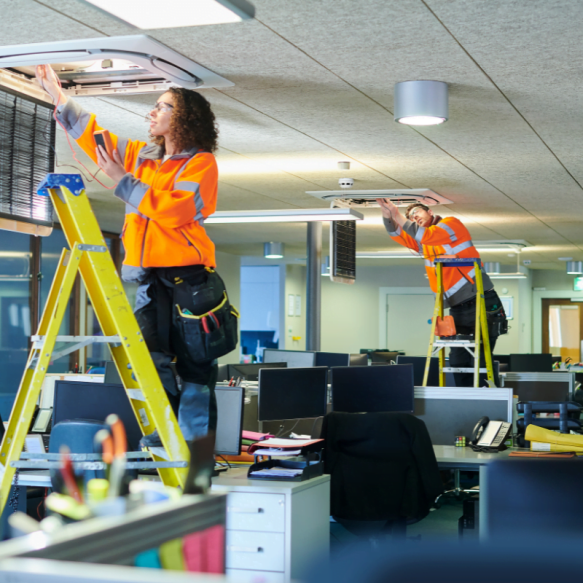 A woman working on a ladder in an office for a Johns Creek HVAC Company.