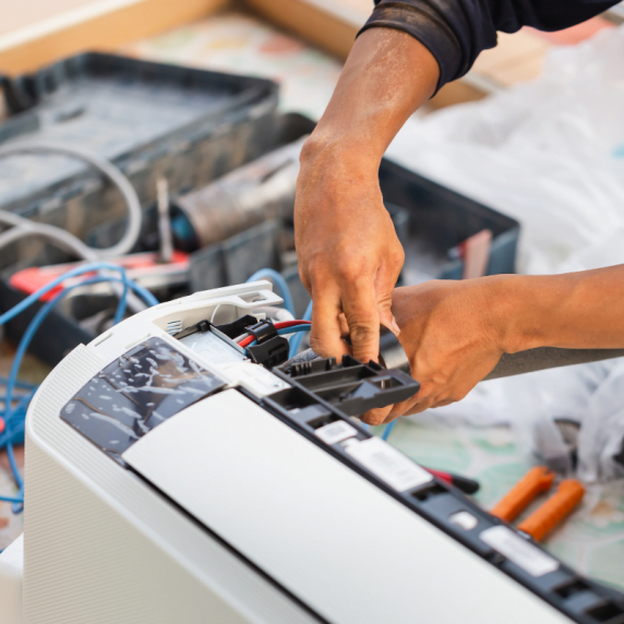 A man is working on an air conditioning unit.