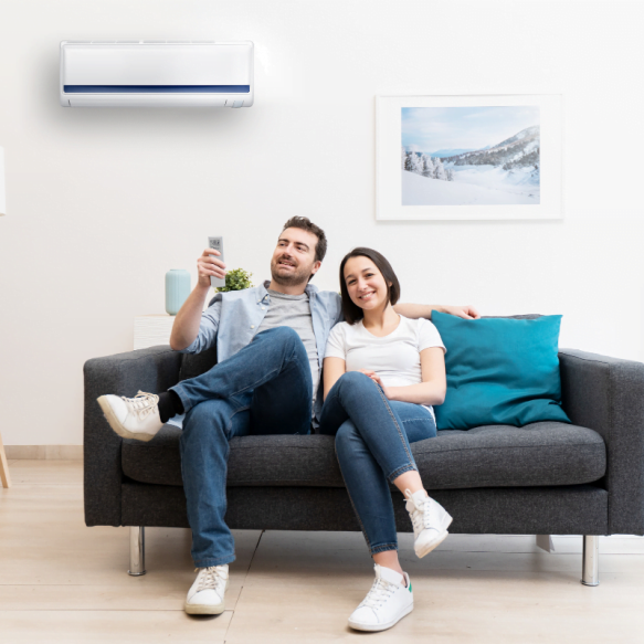 A couple engages in a relaxing day on the couch with their newly installed air conditioner.