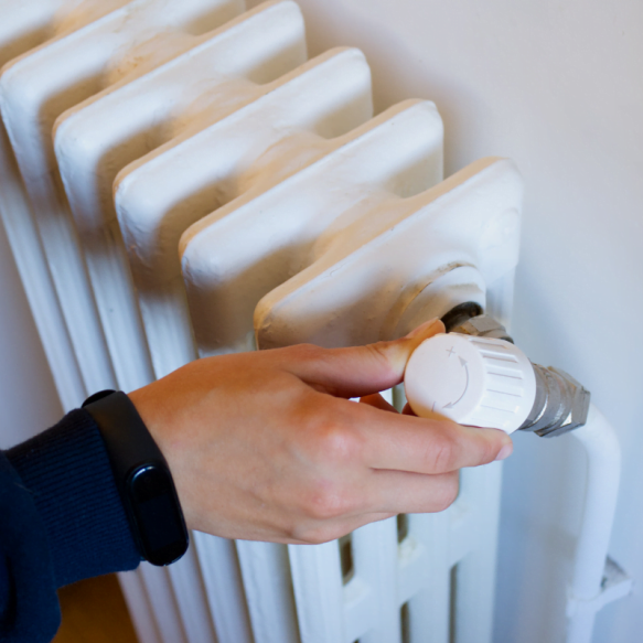 A woman installing a knob on a radiator.