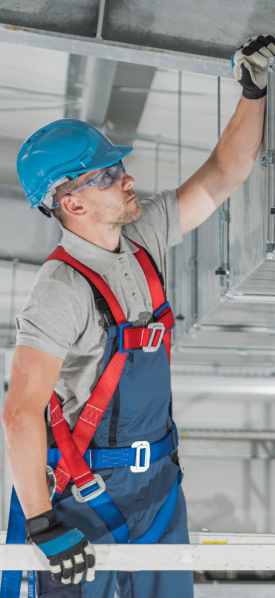 A construction worker from the Marietta HVAC company is working on a ceiling in a building.