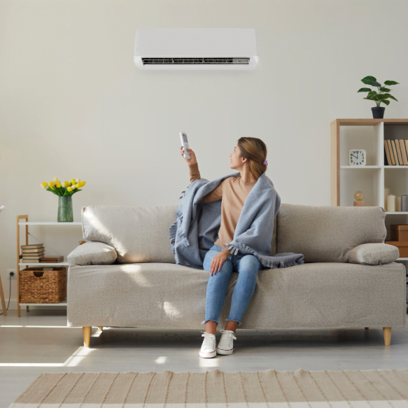 A woman enjoying the comfort of an air conditioner in a living room.